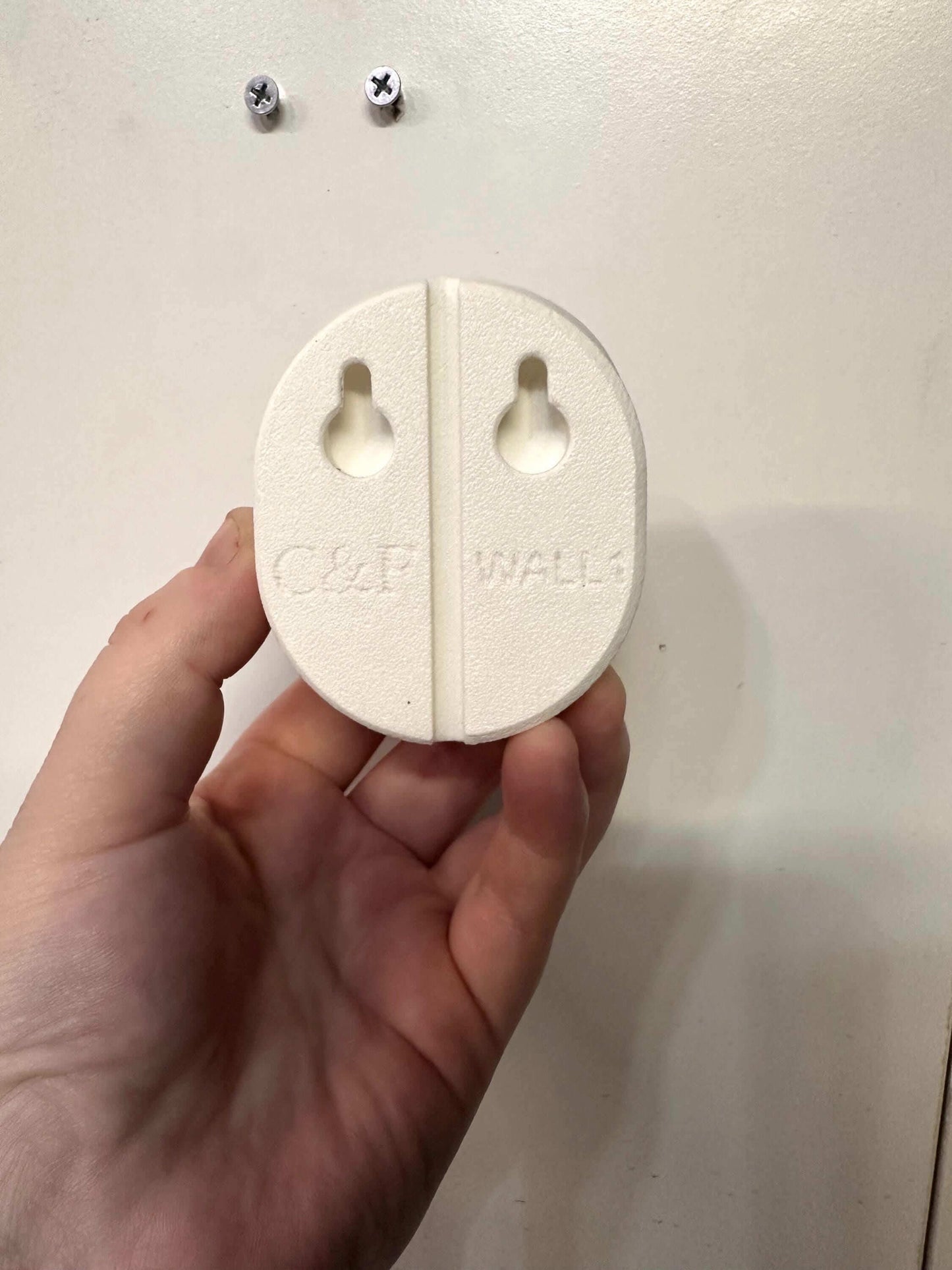 Owlet Baby Monitor Wall Mount | Angled | Cam 2 adapter held in hand for easy installation without drilling.