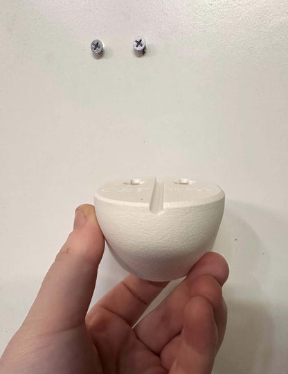 Infant Optics Baby Monitor Wall Mount | Angled | DXR-8 & DXR-8 PRO held in hand before installation on wall.